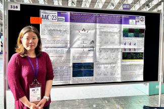 Dr. Sieun Lee stands before her poster at AAIC.