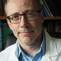 Dr. Moritz wears black framed glasses