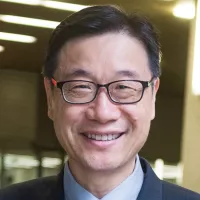Headshot of Dr Kendall Ho, black hair, black eyes, black rectangular framed glasses